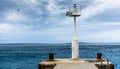 Old pier with a lighthouse beacon and calm sea. Royalty Free Stock Photo