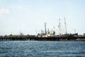 The old pier with rusty ships. Boats are at the broken pier. Repair docks with old bollards Royalty Free Stock Photo