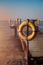 On the old pier sea warning sign in the form of an orange circle Royalty Free Stock Photo