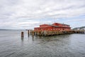 Old pier with wooden flooring and an administrative building for pilot ships in Astoria at the mouth of the Columbia River Royalty Free Stock Photo