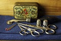 OLD PIN BOX WITH THIMBLES, PAIRS OF SCISSORS, GLASSHEAD PINS AND TRACING WHEEL