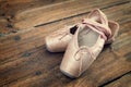 Old pink ballet shoes on a wooden floor Royalty Free Stock Photo