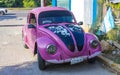 Old pink broken rusty damaged classic vintage cars in Mexico