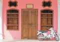 Old pink buildings Sino-Portuguese style with motorcycle in