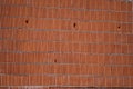 Old pinkish red shabby brick wall background with rough bricks and mortar. several fallen bricks in the wall Royalty Free Stock Photo