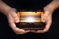 Old pirate chest in hands and white light from it, pirate mystery, concept of magic, fairy tale, wealth and magic, dream of travel Royalty Free Stock Photo