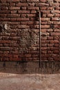 Old pitchfork leaning against red brick wall, old and weathered on a farm Royalty Free Stock Photo