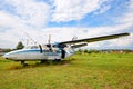 Old plane on the background of beautiful field, green grass and dramatic sky with fluffy clouds