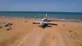 Old plane on beach. Action. Military plane landed on coast of sea many years ago. Abandoned military plane on seashore Royalty Free Stock Photo