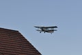 Old plane flying near houses Royalty Free Stock Photo