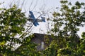 Old plane flying near houses Royalty Free Stock Photo