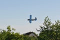 Old plane flying near houses Royalty Free Stock Photo