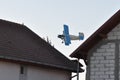 Old plane flying near houses Royalty Free Stock Photo