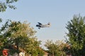 Old plane flying near houses Royalty Free Stock Photo