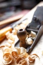 Old plane on wooden board, carpentry tools with wood shavings