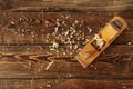 Old planer and shavings on dark wooden table