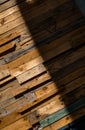 Old planks of various sizes and colors by random in shadow