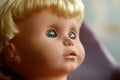 Old plastic doll with blonde hair.