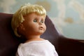 Old plastic doll with blonde hair.