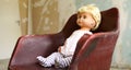 Old plastic doll with blonde hair.