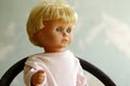 Old plastic doll with blonde hair.