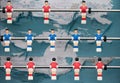 An old plastic football game with figures on sticks. The figures hang like puppets over the tattered and old football field. The