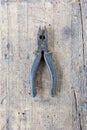 Old pliers pincers hand tool against wooden plank. Royalty Free Stock Photo