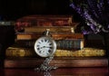Old pocket watch with chain and books on a table Royalty Free Stock Photo