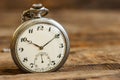 Old pocket watch and chain, vintage locket watch on chestnut rustic wooden background