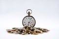 Old pocket watch with open cover on scattered coins Royalty Free Stock Photo