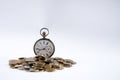 Old pocket watch with open cover on scattered coins Royalty Free Stock Photo