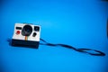 Old Polaroid camera isolated on a blue background