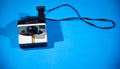 Old Polaroid camera isolated on a blue background