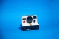 Old Polaroid camera isolated on a blue background