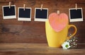Old polaroid photo frames hanging on a rope with coffee cup and cookies over wooden background Royalty Free Stock Photo