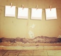 Old polaroid photo frames hanging on a rope over textured grunge wall and floor pattern Royalty Free Stock Photo