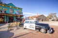 Old police car in front of historic Sundries Building.