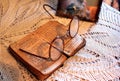 Old Polish Bible, retro spectacles and vintage mirror on a tablecloth. Old age, senility and poverty concept.