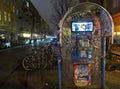 An old, polluted phone booth smeared with graffiti.