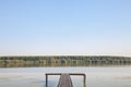 Old pontoon on the Danube river in Dubovac, Serbia, during a sunny afternoon, facing a green forest.