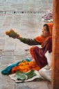 Old poor woman sells garlands of flowers at the temple Royalty Free Stock Photo