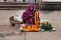 Old poor woman sells garlands of flowers at the temple Royalty Free Stock Photo