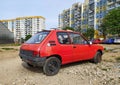 Old classic rusty small compact car Peugeot 205 rear view from eighties parked