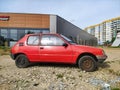 Old classic rusty small compact car Peugeot 205 from eighties parked