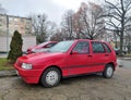 Old classic small veteran Italian popular red Fiat Uno Fire 1.0 I.e.s parked