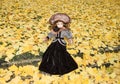 old porcelain doll on blur ginkgo leave background Royalty Free Stock Photo