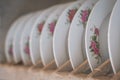 Old porcelain plates with floral decoration in wooden shelf - Royalty Free Stock Photo