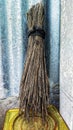 old porous broom on a yellow can tin roof background