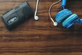 old portable reel-to-reel mini tape-recorder with bluetooth microphone and earphones on wood table.