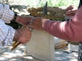 An old Portuguese couple wrapping a sheep skin around a traditional drum